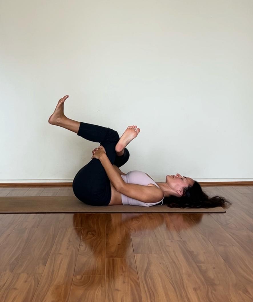 Diana demonstrating a reclined hip-opening yoga therapy pose