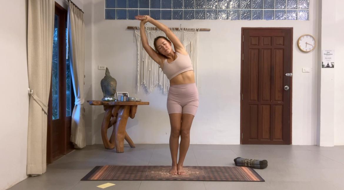 Diana in a standing side stretch during a one-on-one yoga therapy session